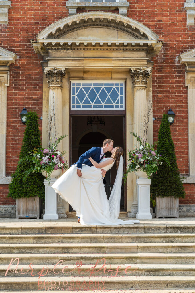 Photo of bride and groom kissing outside their wedding venue in Milton Keynes