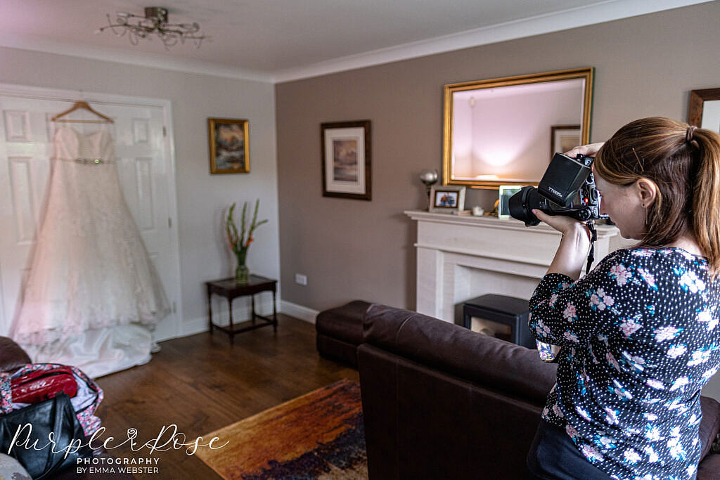 Wedding photographer photographing a wedding dress