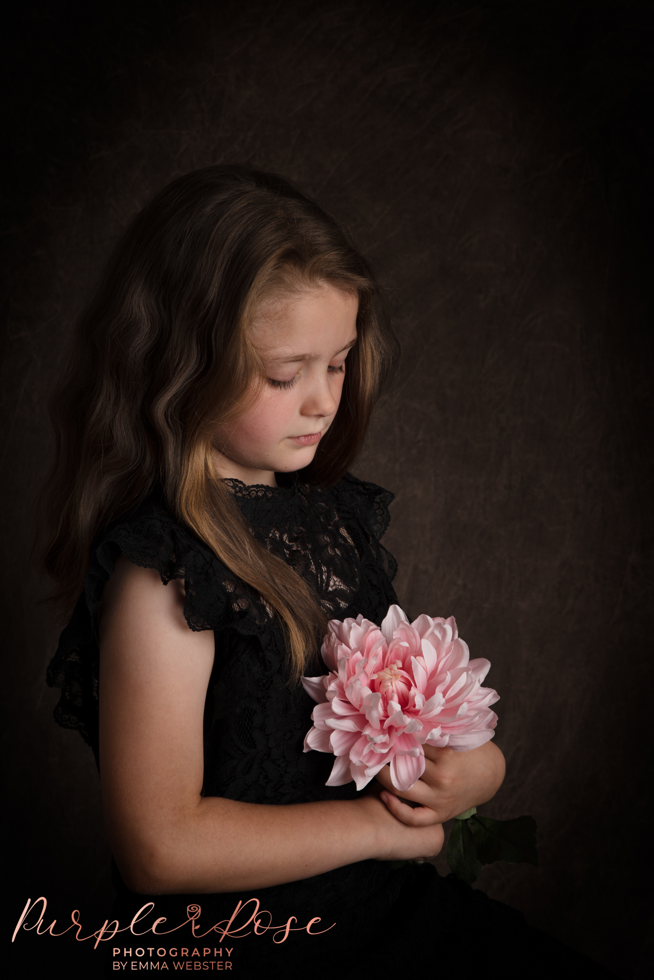 Child looking at a flower