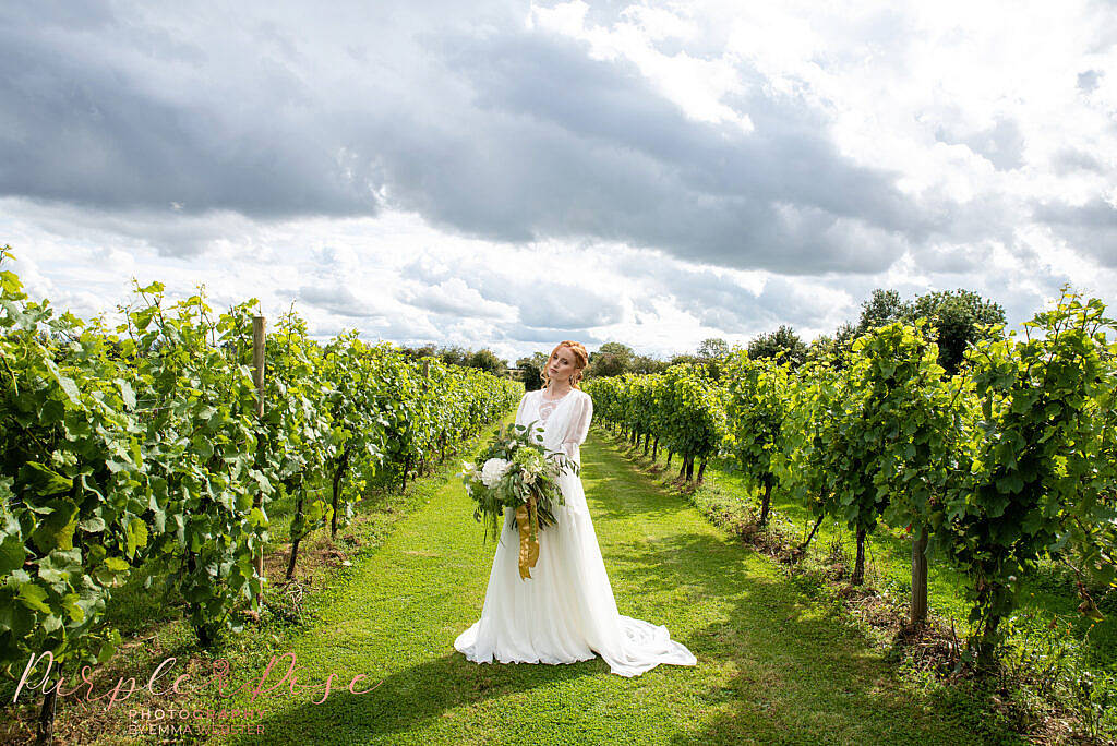 Bride holding bouquet in a vineyard