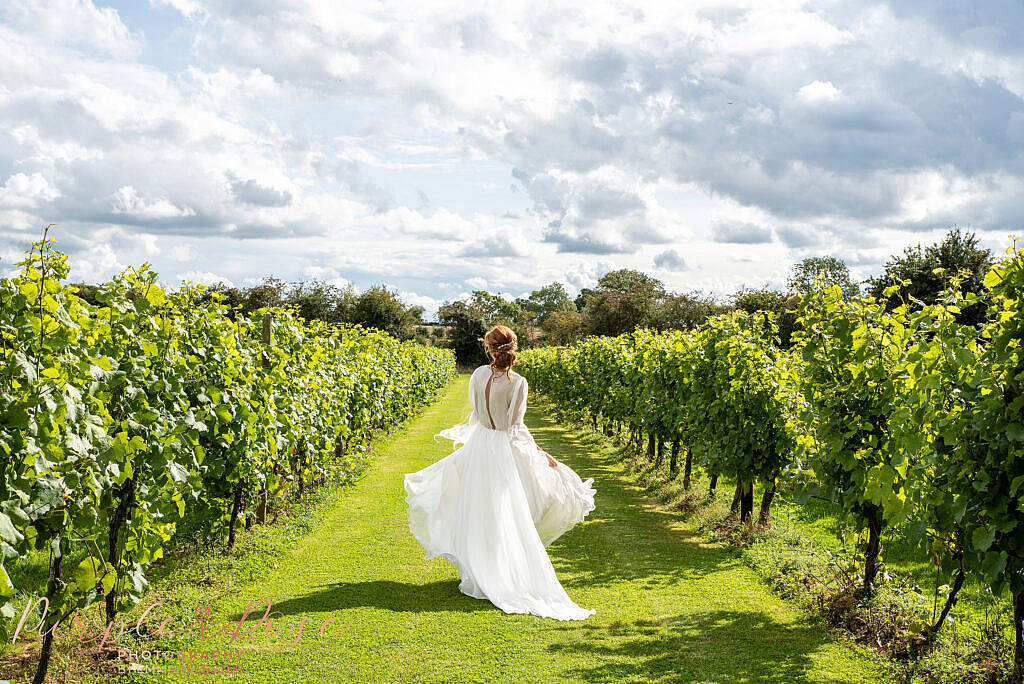 Bride skipping down a vineyard