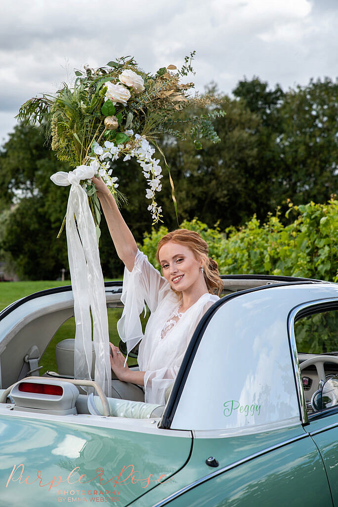 Bride standing out of car sun roof