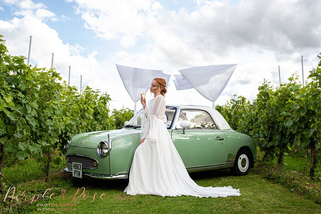 Bride stood in front of wedding car
