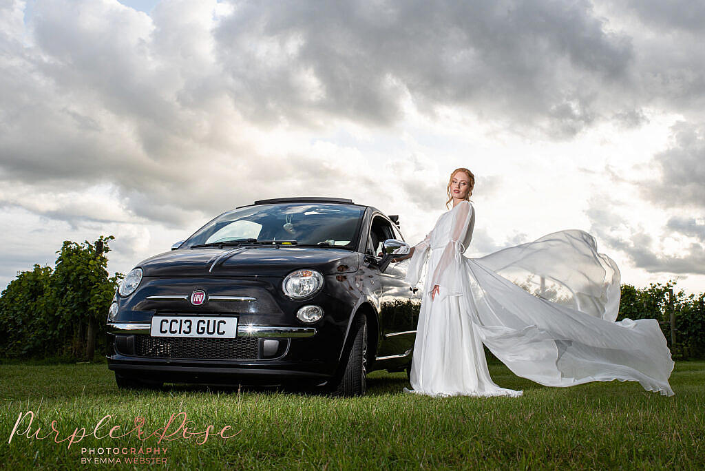 Bride stood next to wedding car