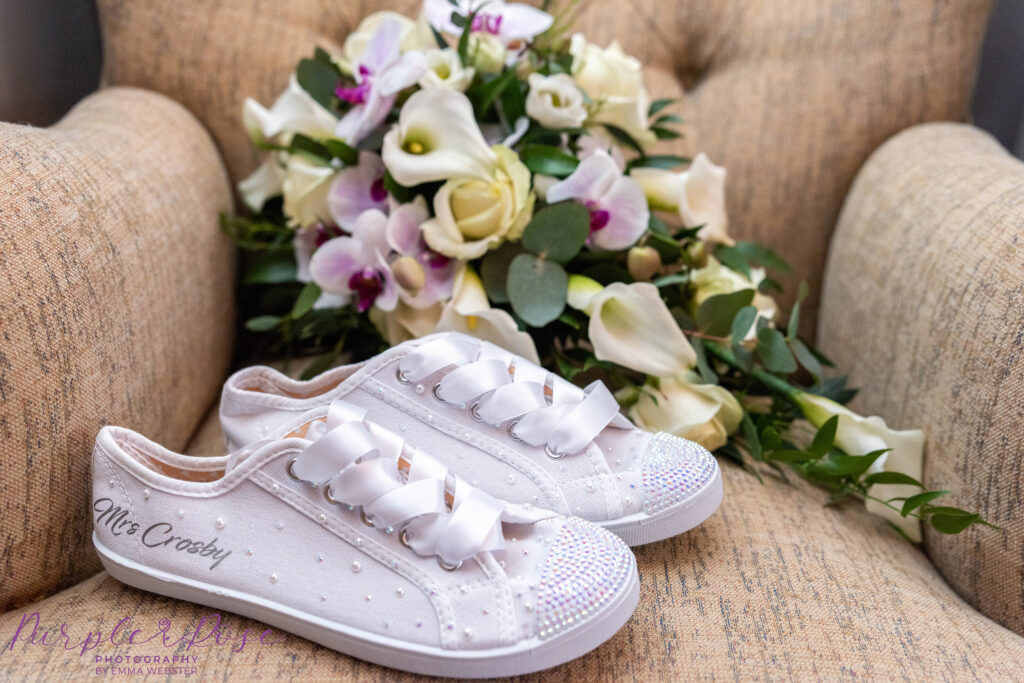 Brides bouquet and canvas trainers