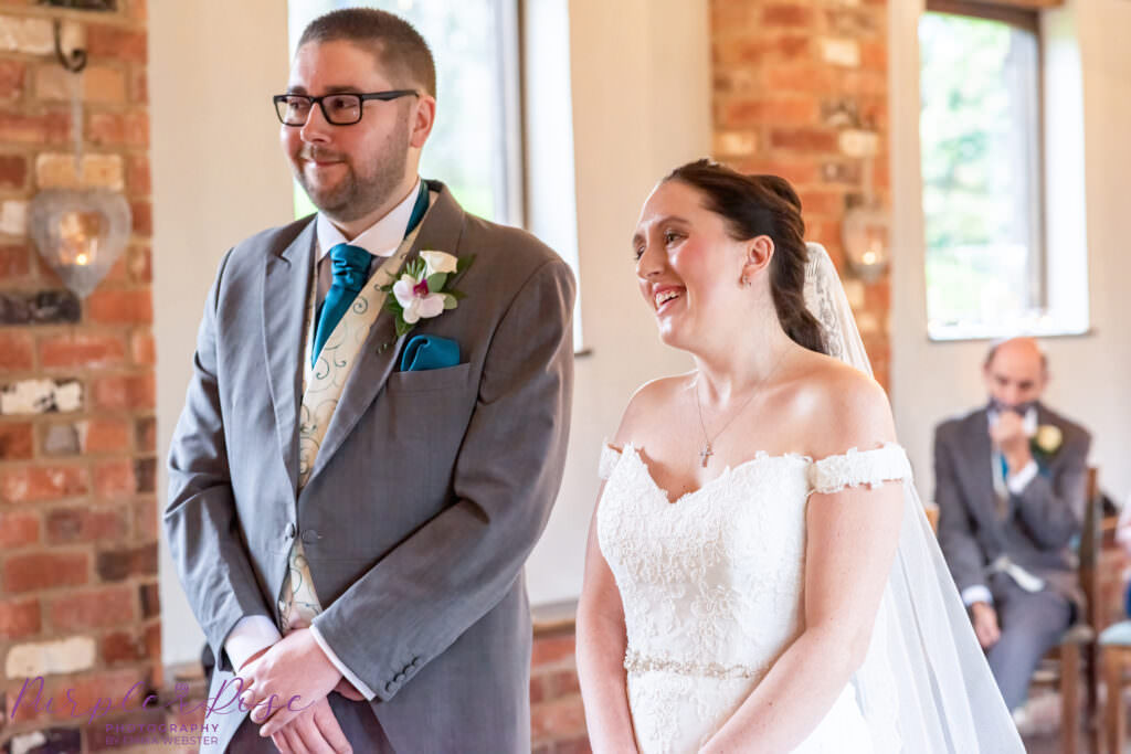 Bride and groom smiling during their wedding ceremony