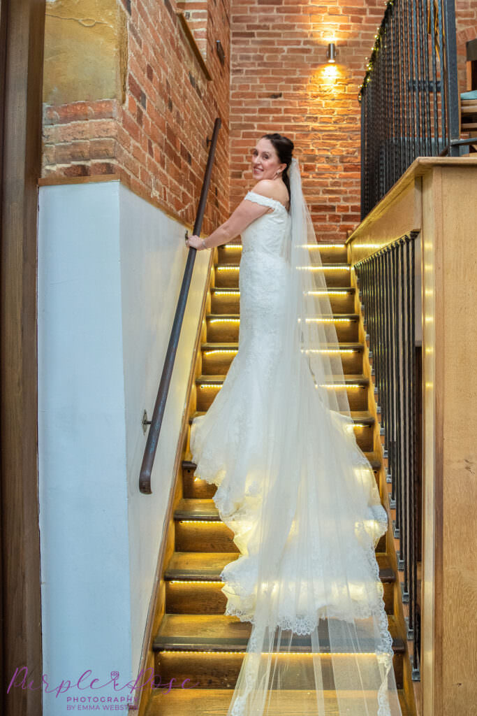 Bride walking up a backlit staircase