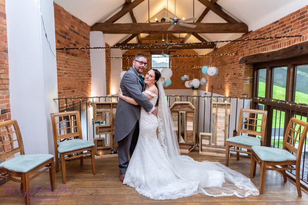 Bride and groom hugging a barn venue