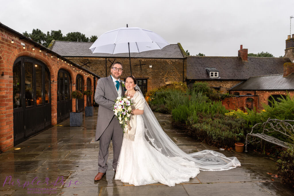 Bride and groom under an umbrella