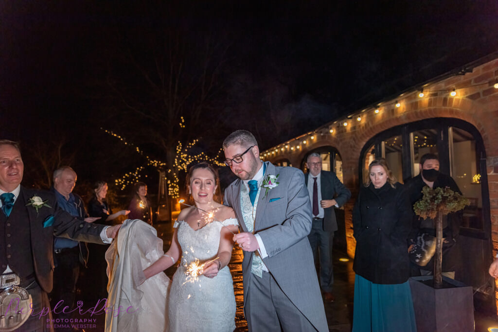 Bride and groom playing with sparklers