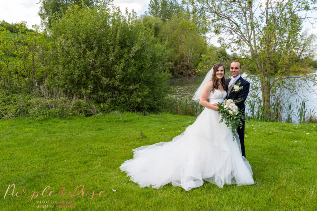 Couple in front of a lake on their wedding day