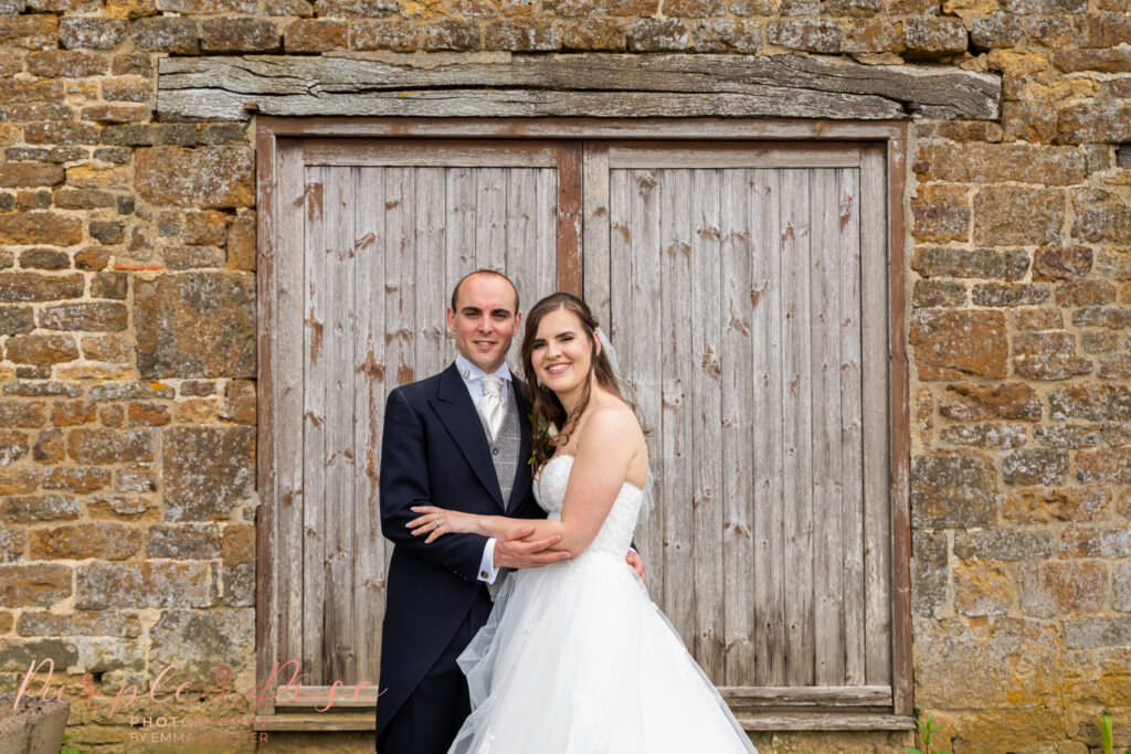 Bride and groom in front of a barn