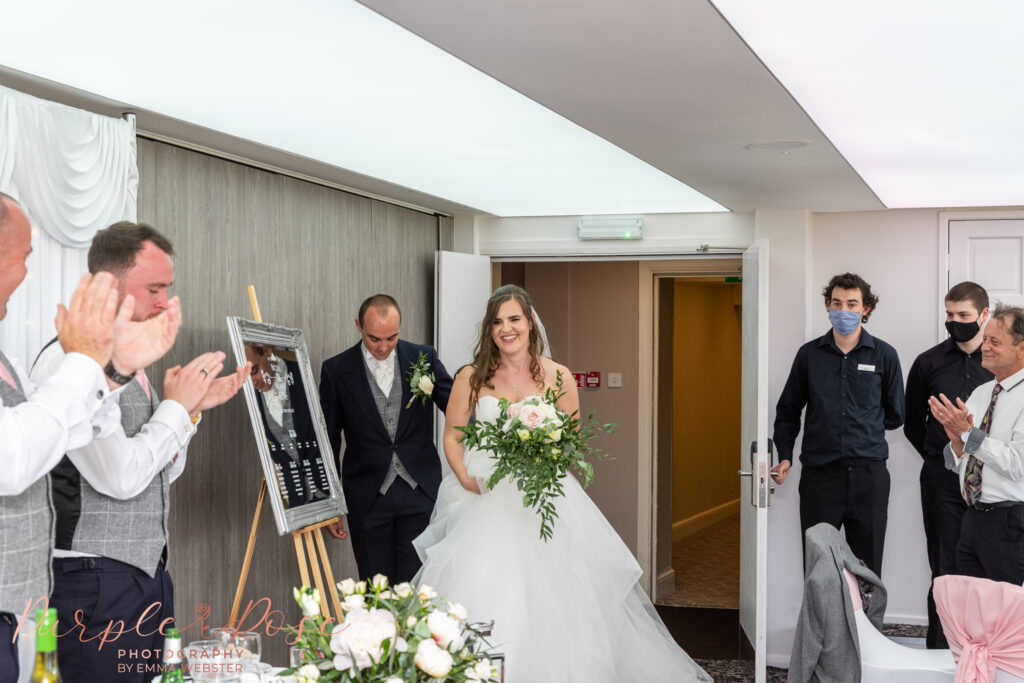 Bride and groom walking into their wedding reception