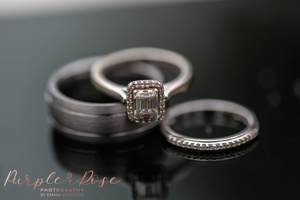 wedding and engagement rings on a reflective surface