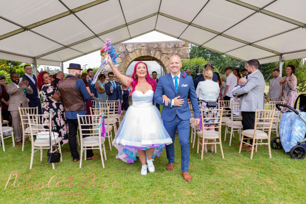 Bride and groom laughing as their leave their wedding ceremony