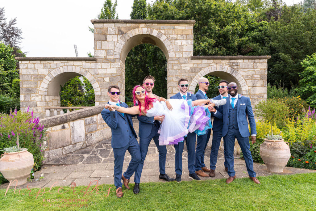 Groomsmen lifting bride