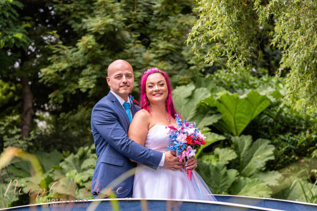 Bride and groom stood on a blue bridge