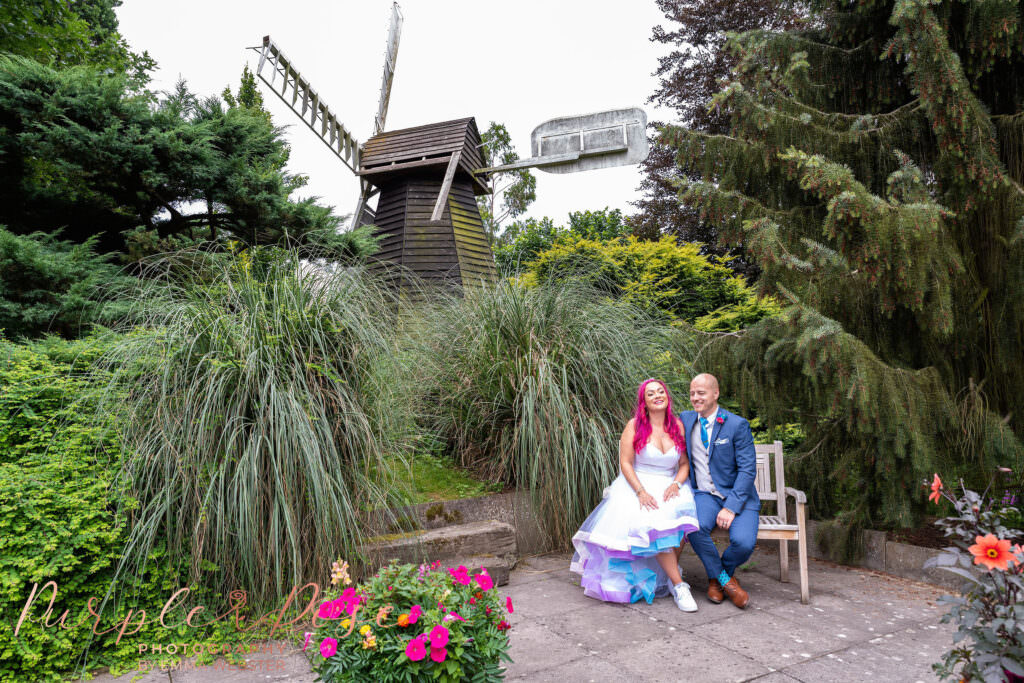 Bride and groom sat by a windmill