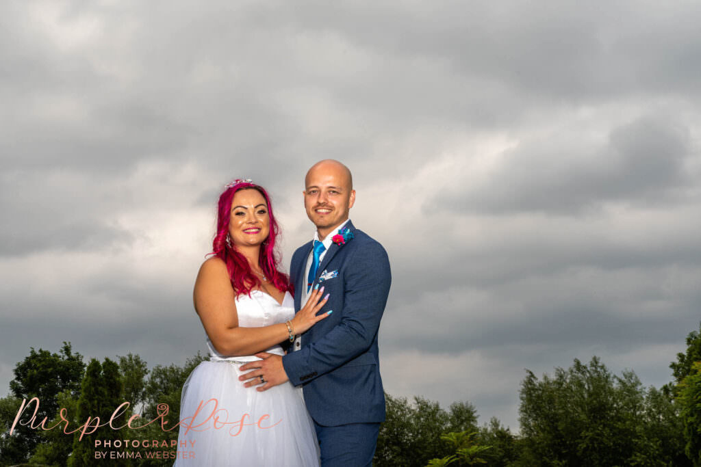 Bride and groom in front of a stormy sky
