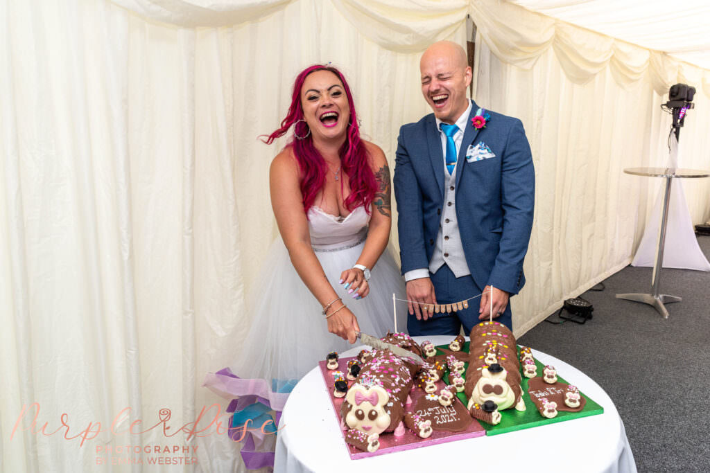 Bride and groom cutting caterpillar cakes