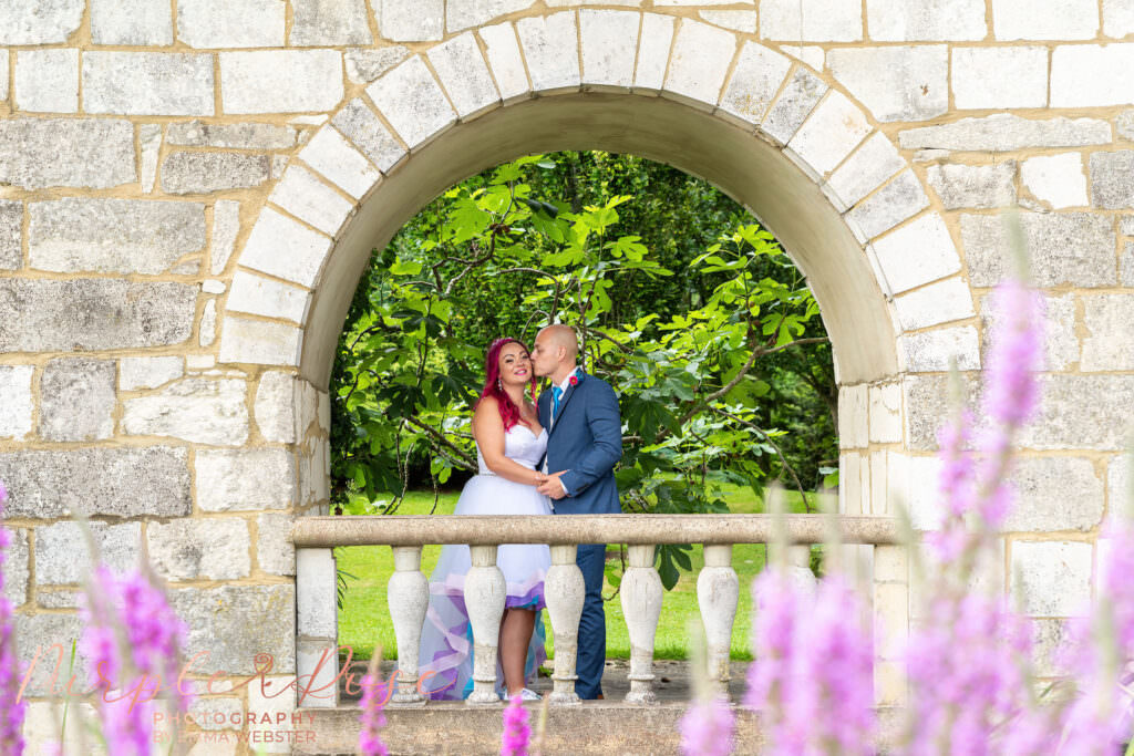 Bride and groom under brick archway