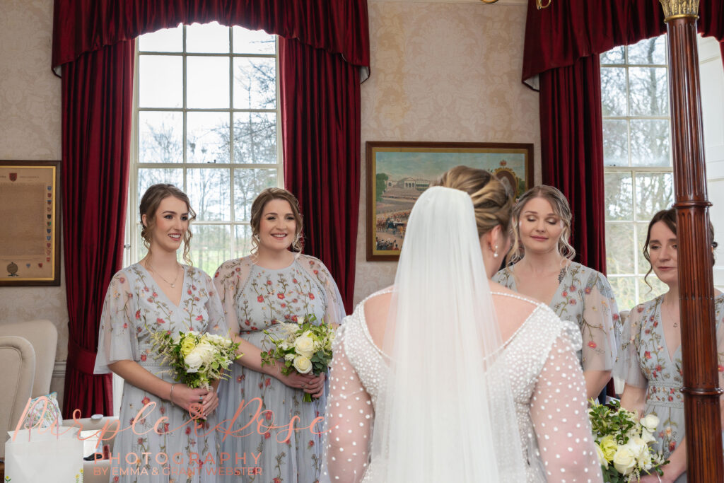 Photo of bridesmaids seeing the bride in her wedding dress for the first time on her wedding day in Milton Keynes