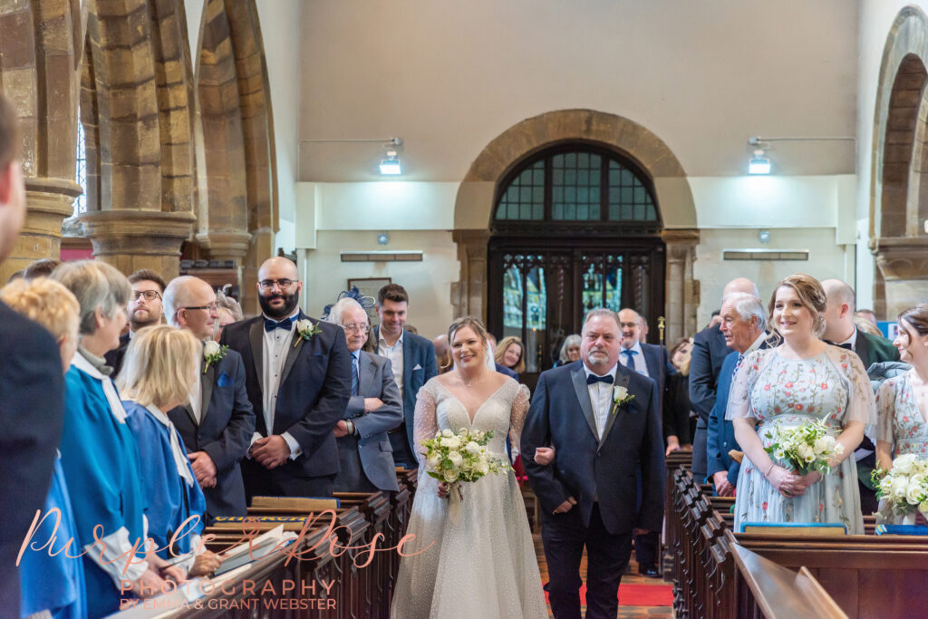 Photo of bride walking in the church to start her wedding ceremony in Milton Keynes
