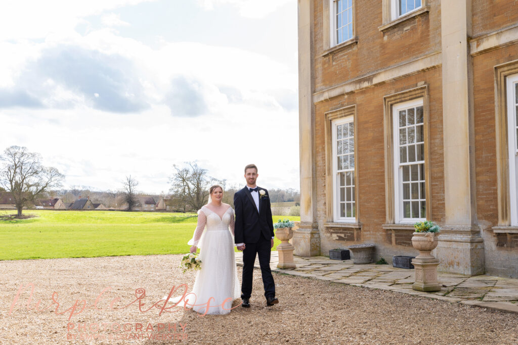 Photo of bride and groom walking hand in hand on their wedding day in Milton Keynes