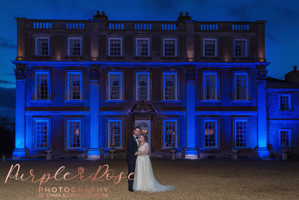 Night time photo of bride and groom outside their wedding venue in Milton Keynes