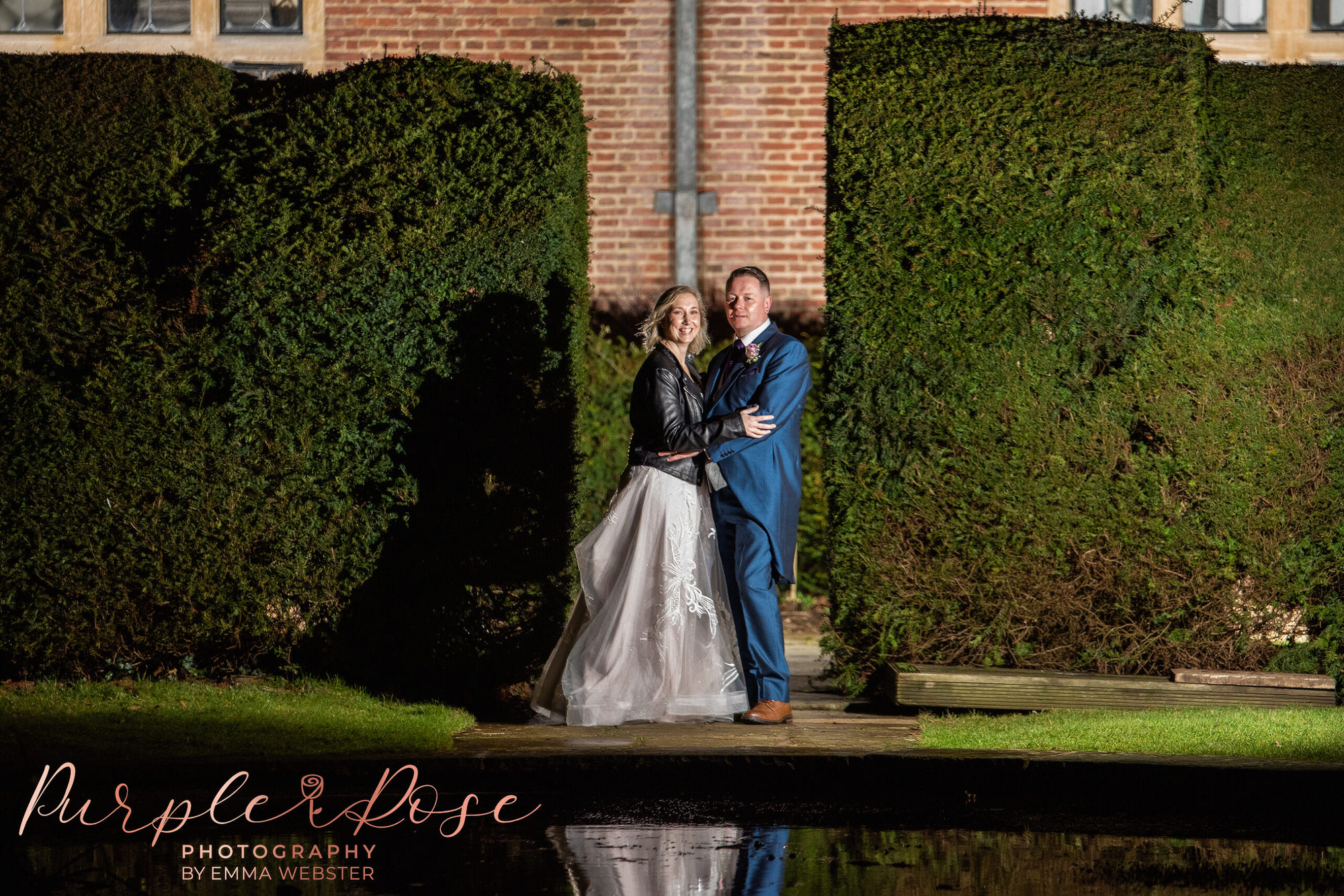 Bride and groom in front of a pond at night