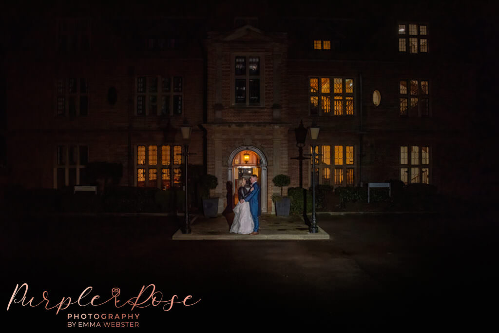 Bride and groom in front of their wedding venue in the evening