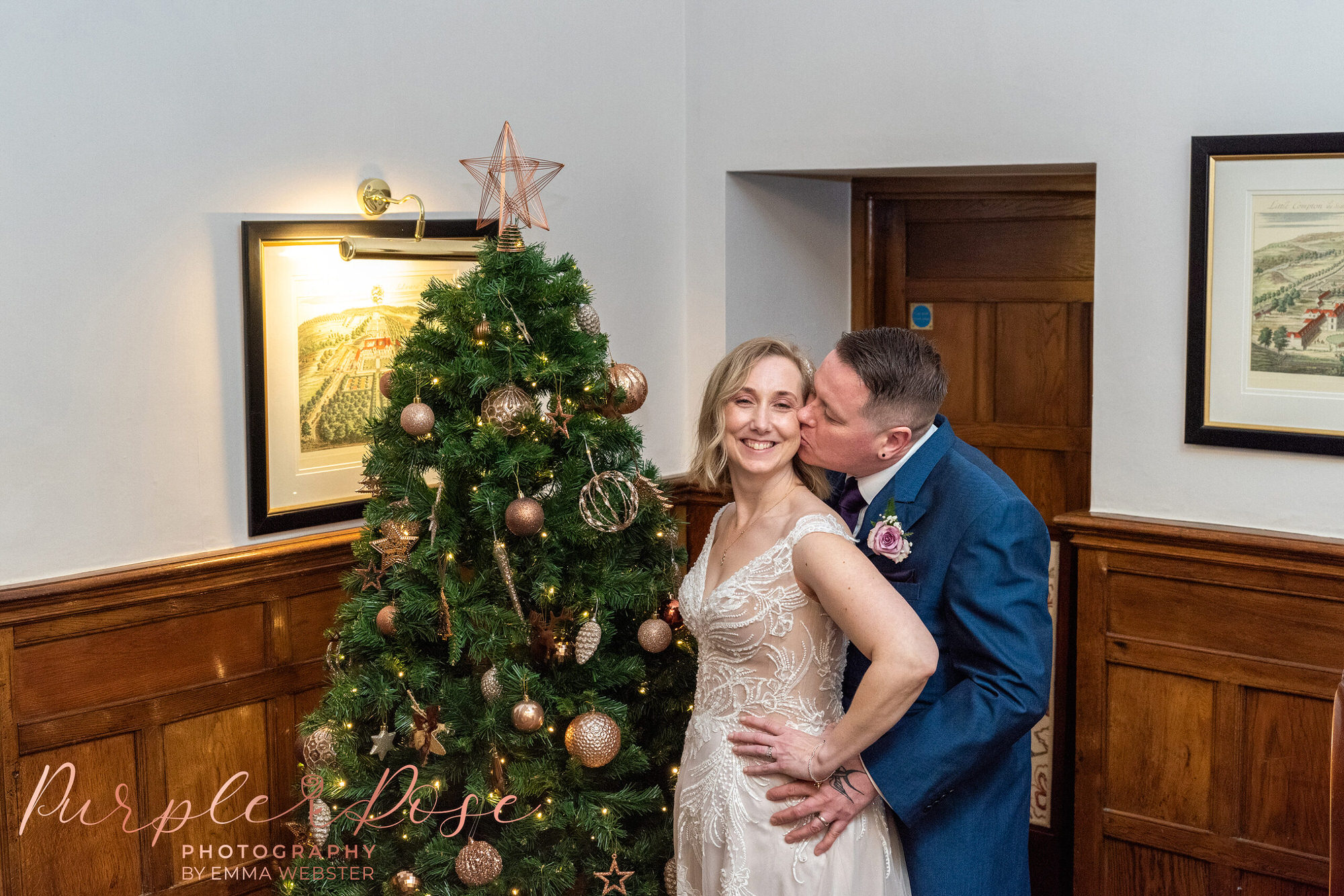 Bride and groom by a Christmas tree