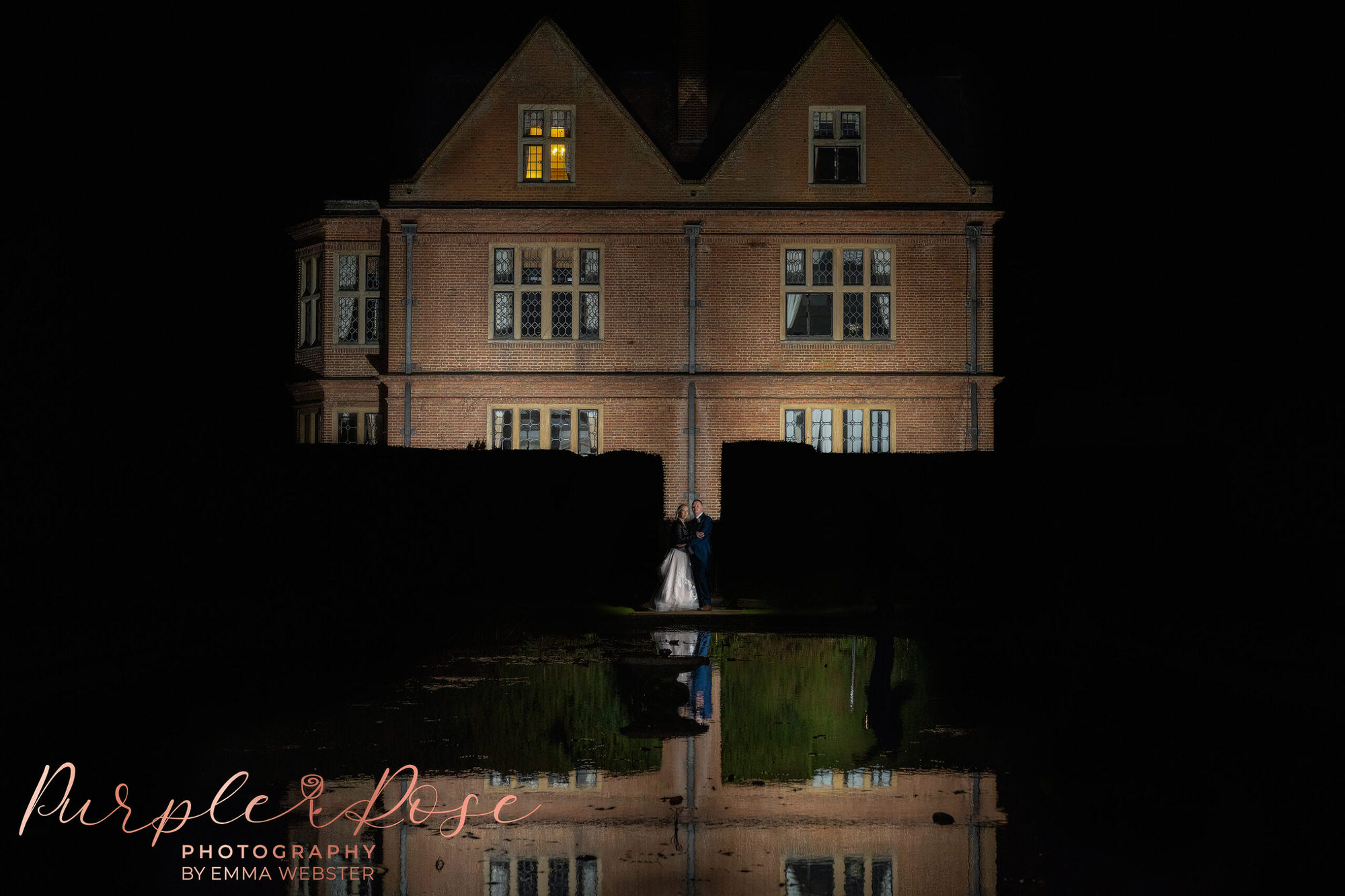 Bride and groom at night by pond