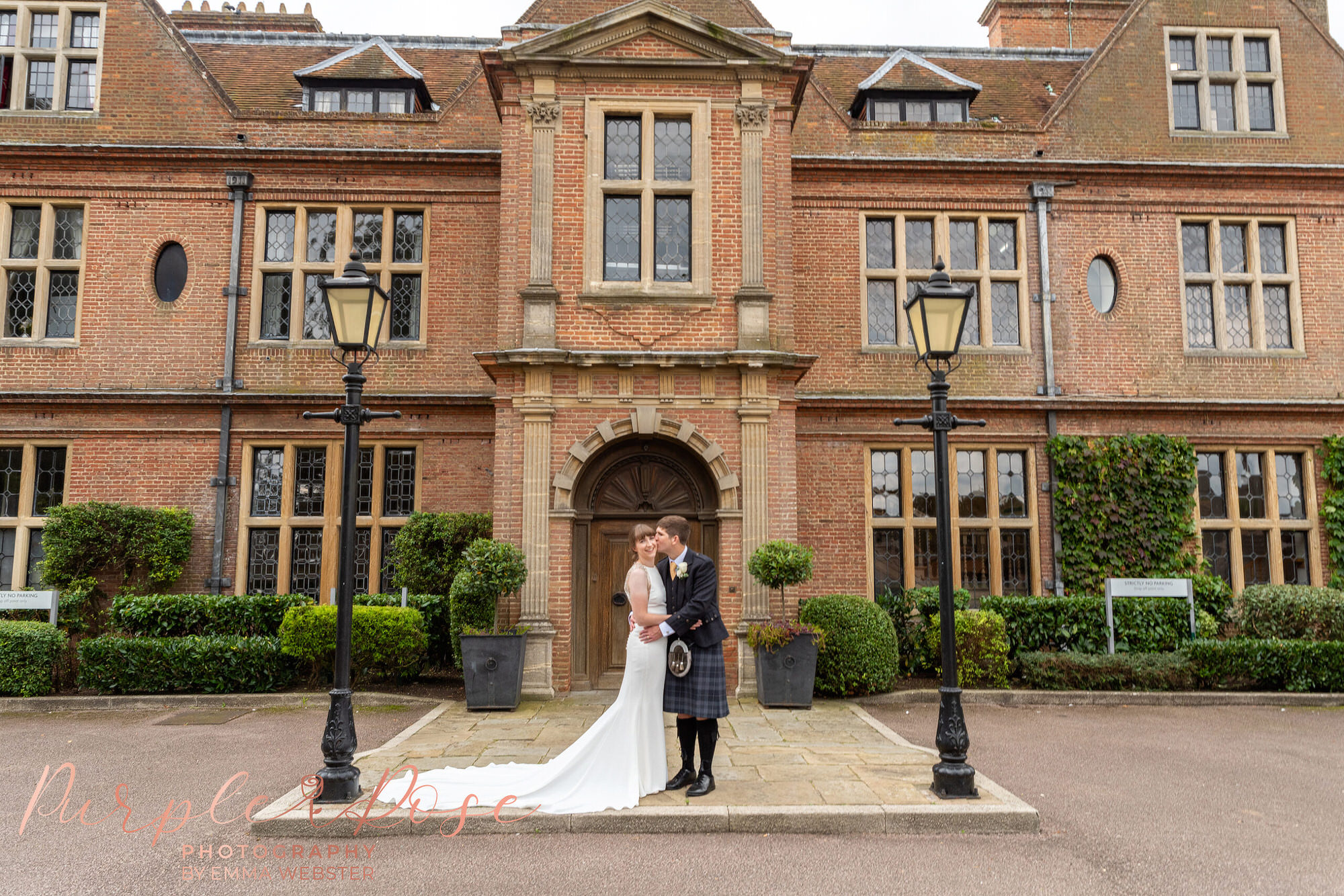 Bride and groom stood on their wedding venues door step