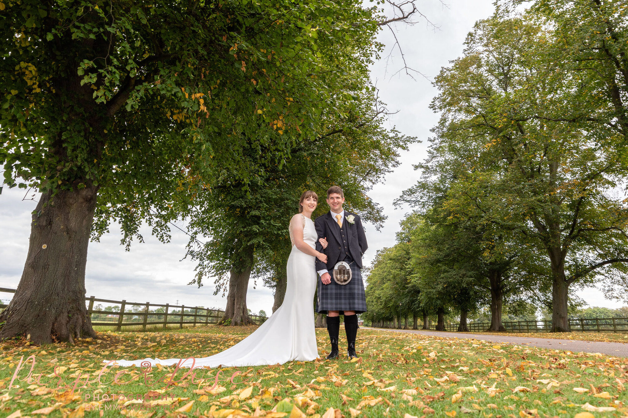 Bride and groom stood amongst autumn leaf's