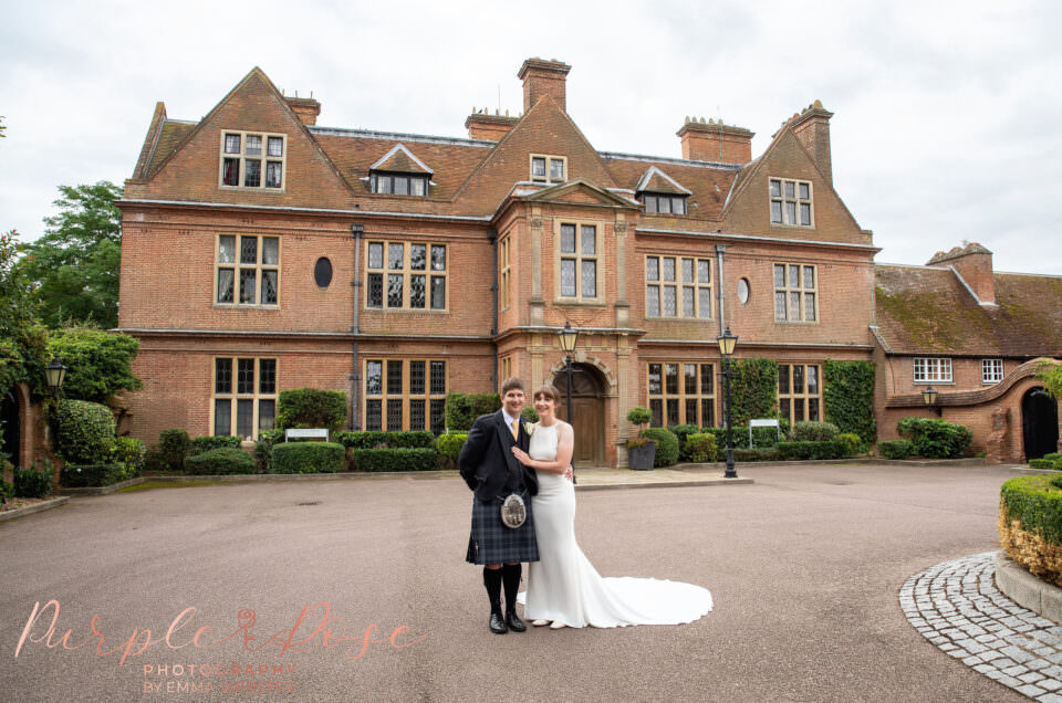 Bride and groom in front of their wedding venue Horwood House