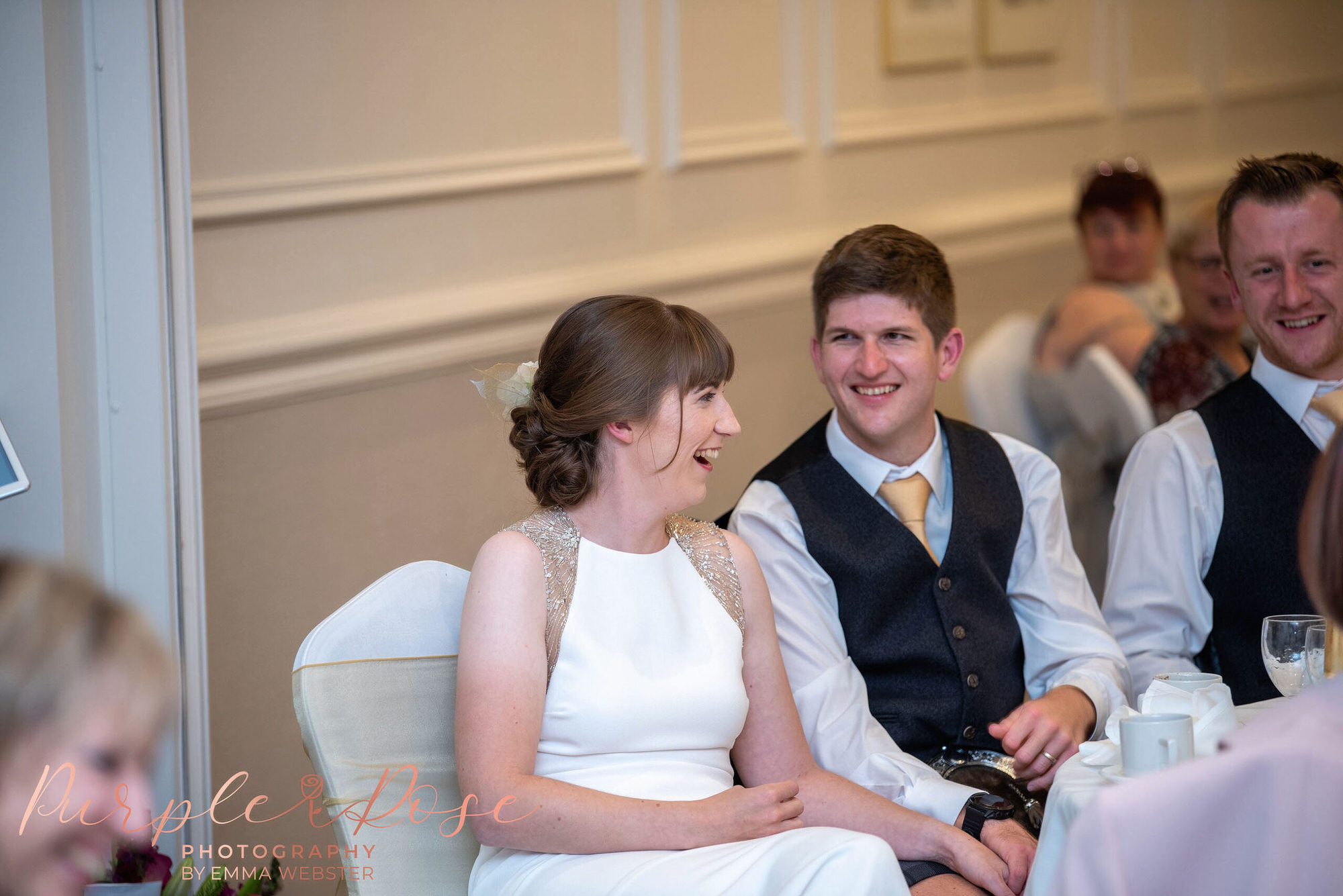 Bride and groom laughing during speeches