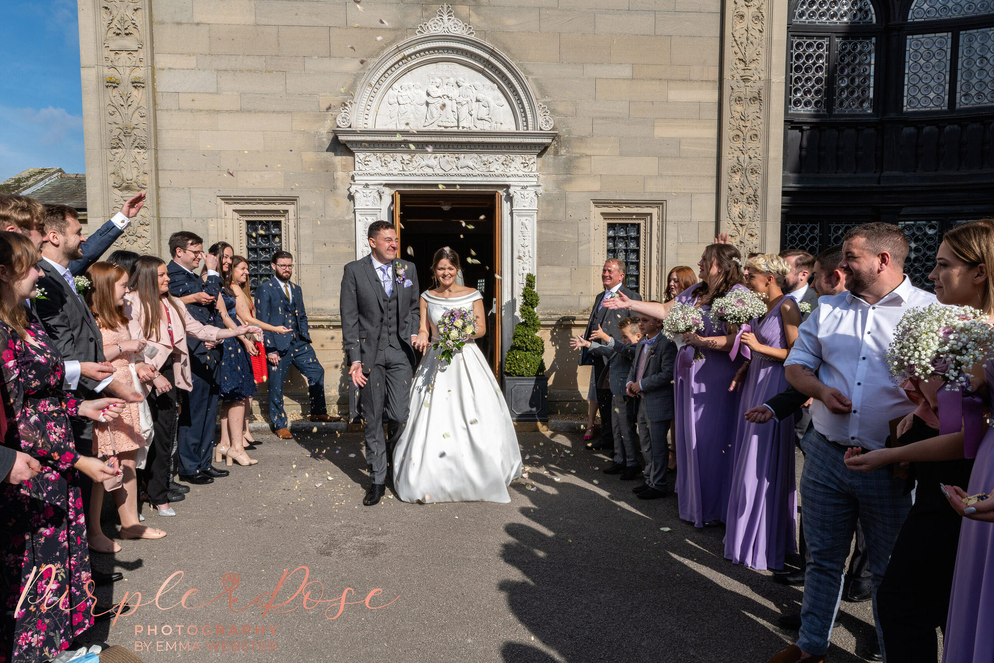 Bride and groom walking through confetti