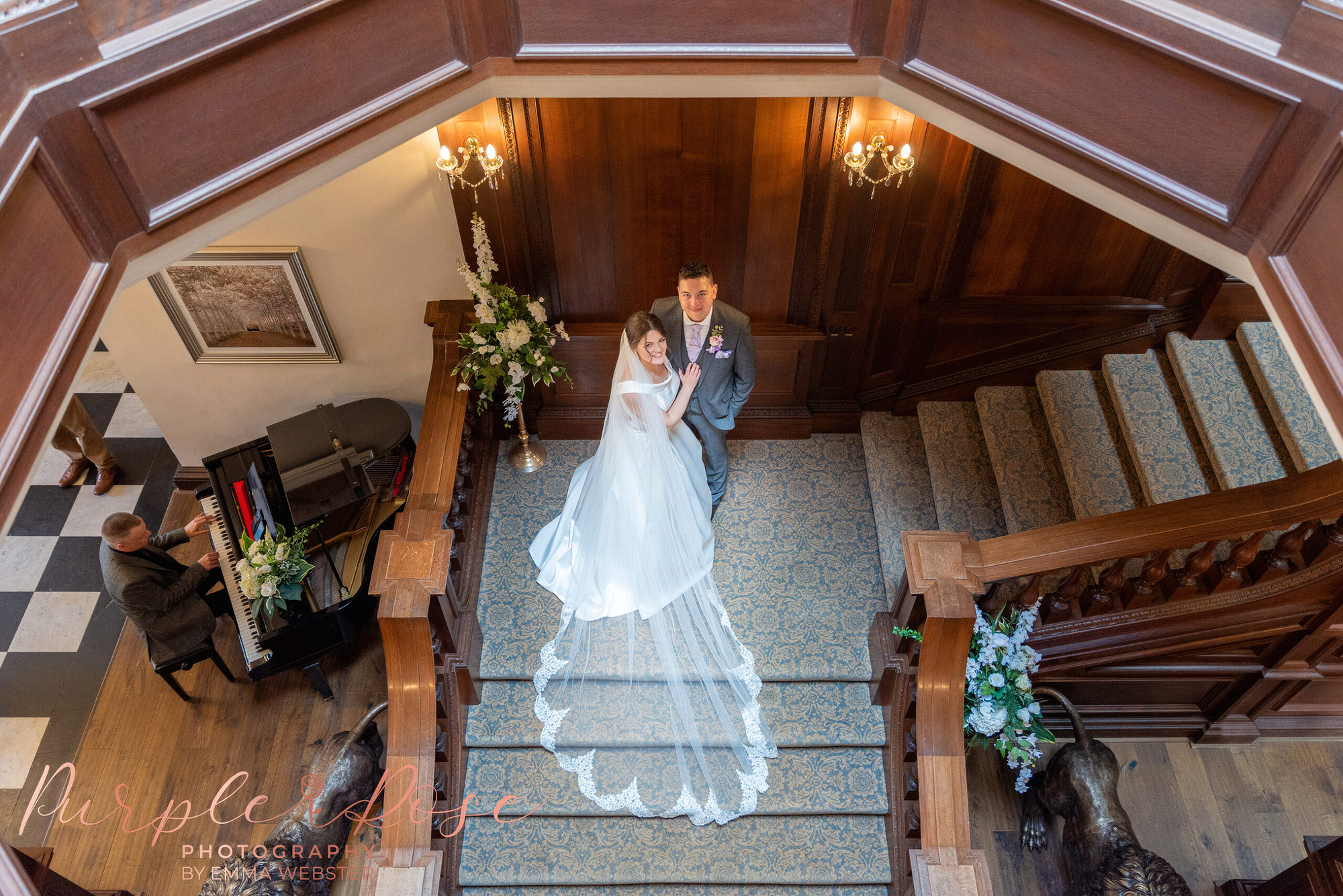 Bride and groom looking up from a staircase