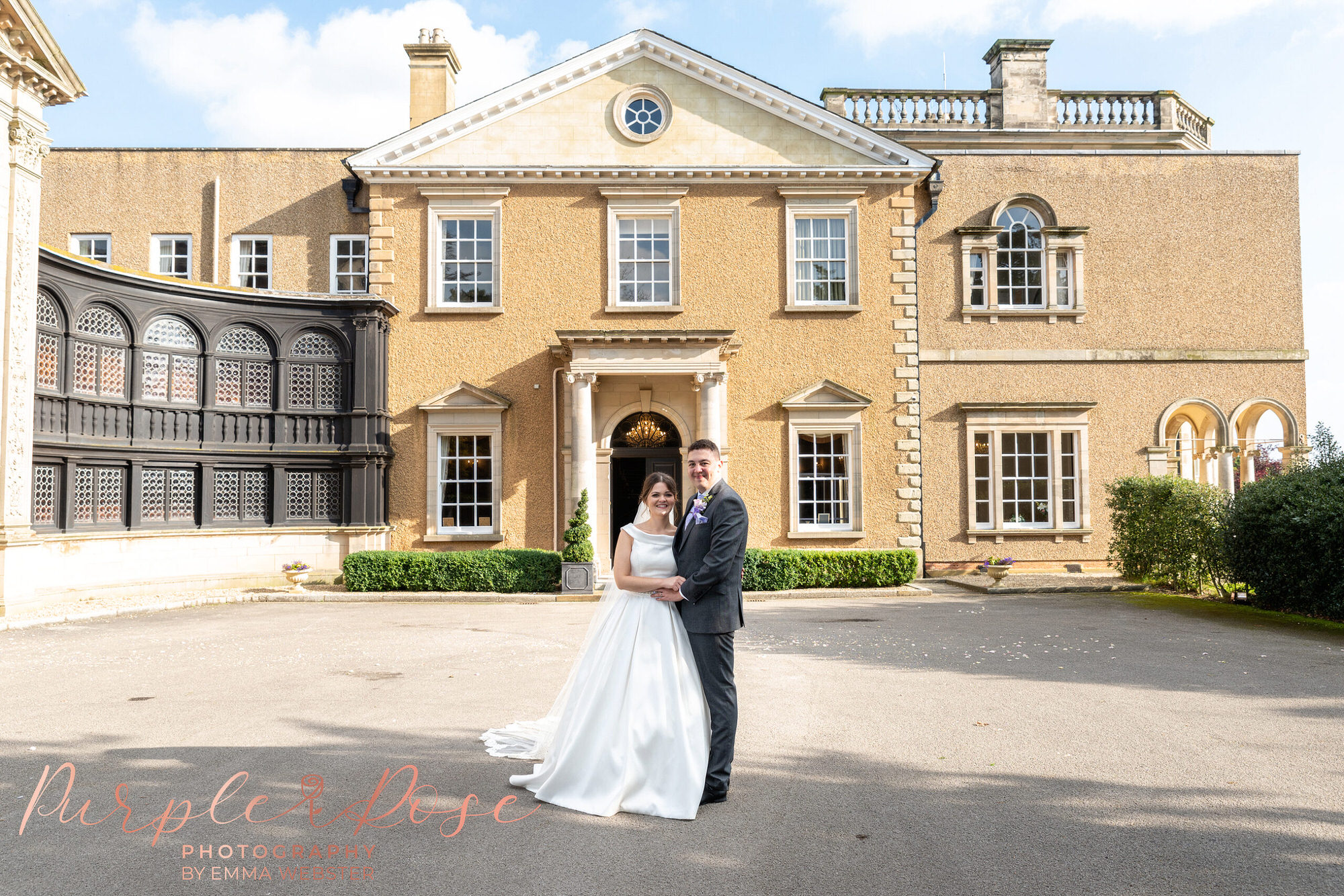 Bride and groom stood in front of their wedding venue