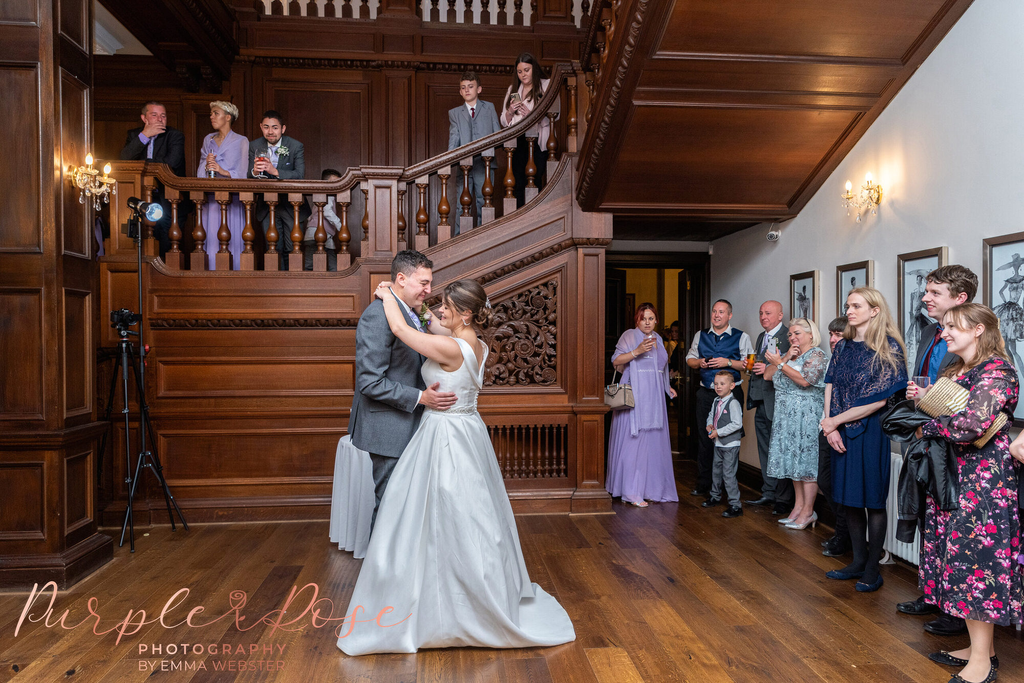 Bride and groom surrounded by wedding guests as they dance