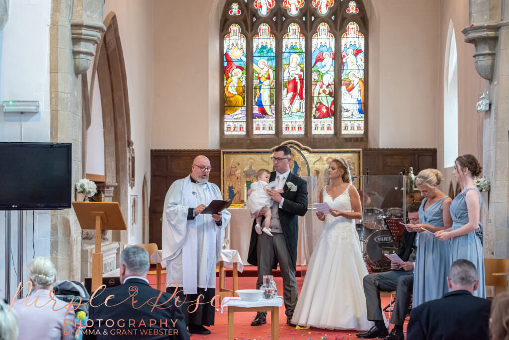 Bride, groom and baby during wedding ceremony