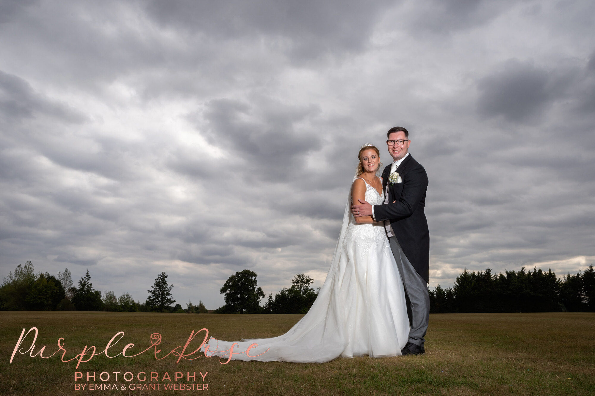 Bride and groom in front of a stormy grey sky