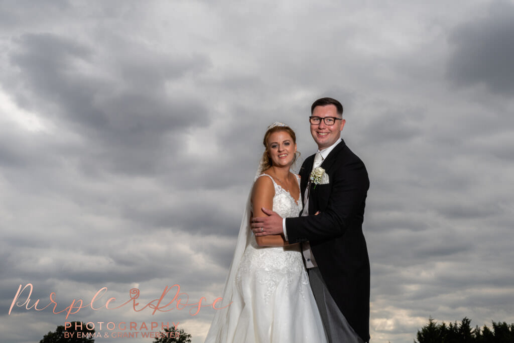 Bride and groom in fornt of stormy sky