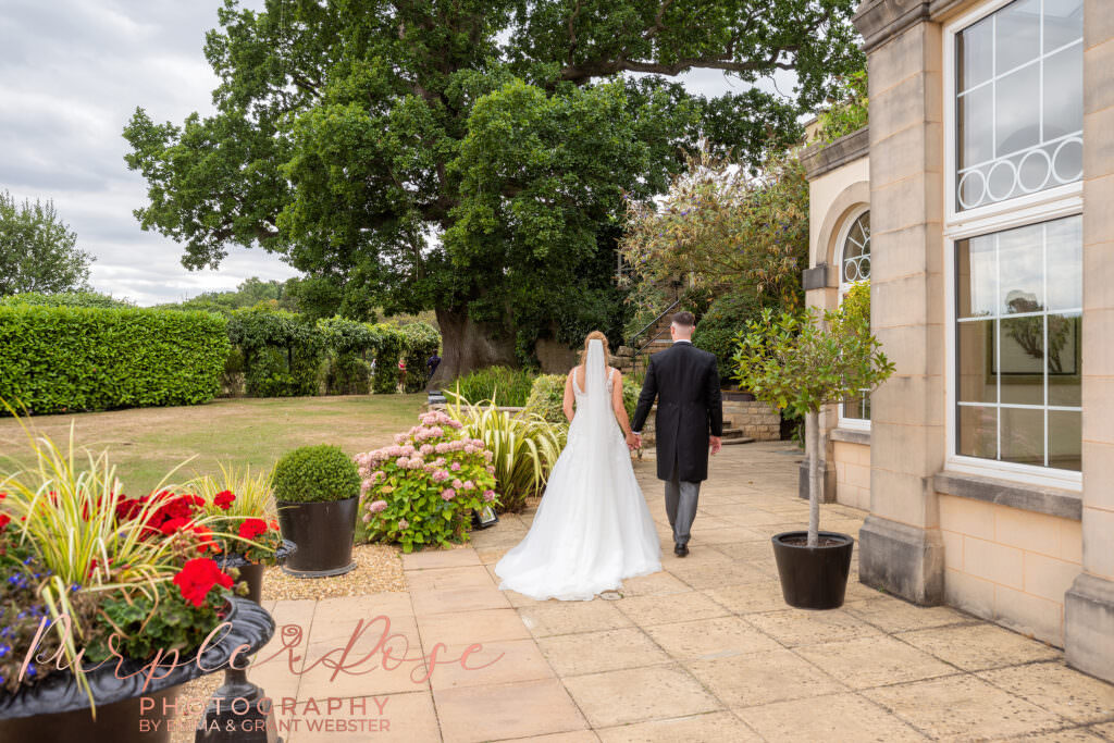 Bride and groom walking away hand in hand