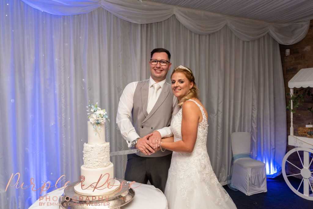 Bride and groom cutting their wedding cake.