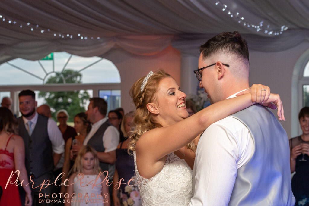 Bride and groom laughing while dancing