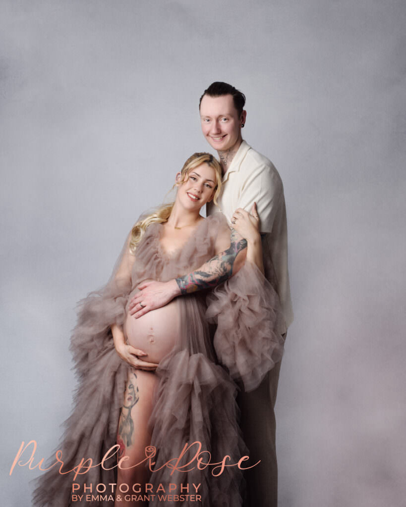 Mother and father to be embracing during their maternity photoshoot in Milton Keynes