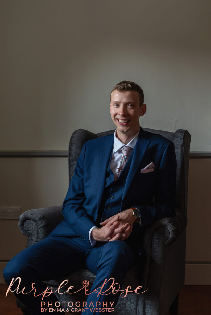 Photo of groom sat in a chair before his wedding ceremony in Milton Keynes