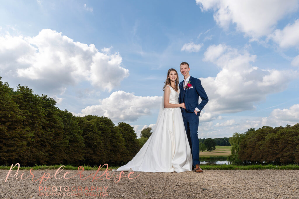 Photo of bride and groom in fornt of a blue sky on their wedding day in Milton Keynes